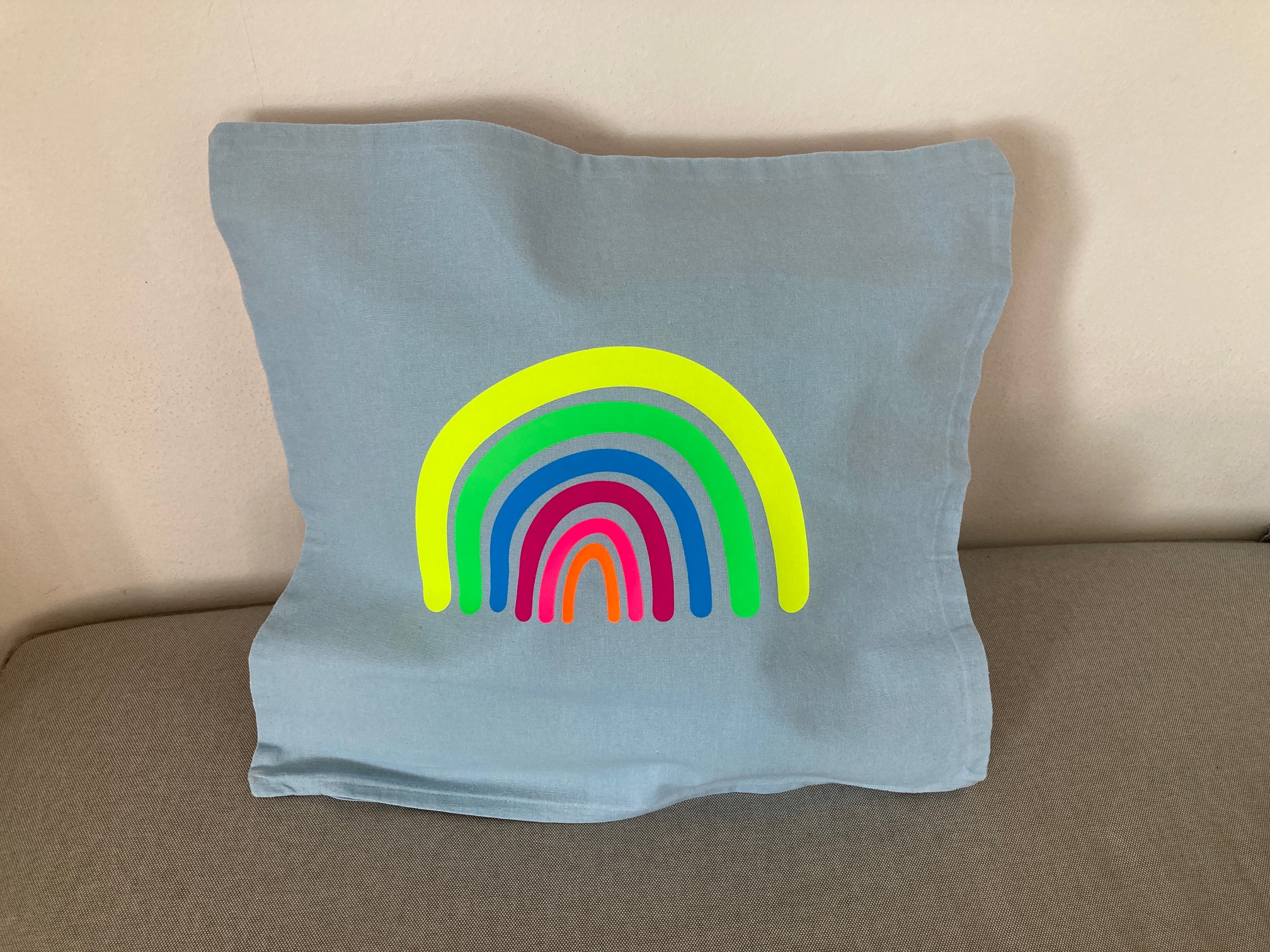 Kissenhülle mit Regenbogen in Neonfarben, hellblau/gelb